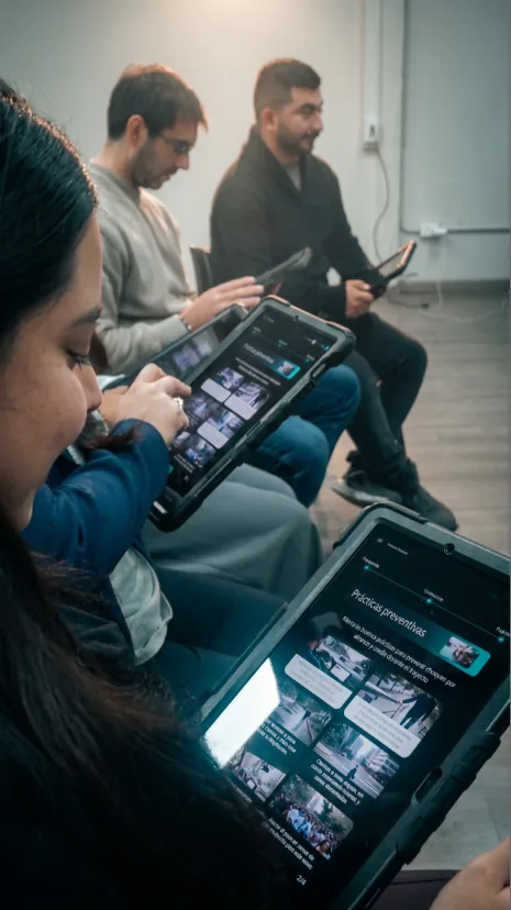 Equipo revisando prácticas preventivas en tablets durante el entrenamiento CoreOne